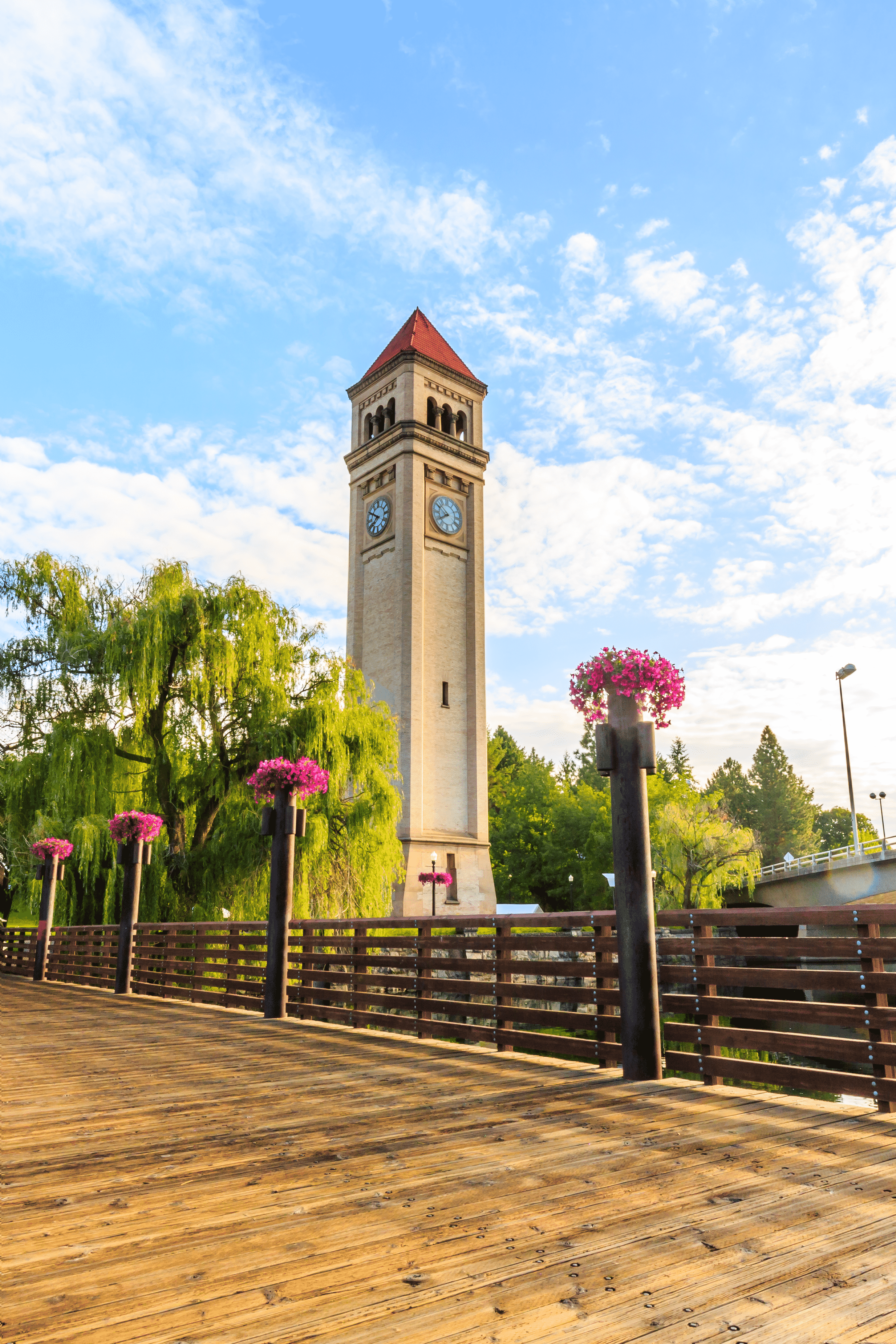 The Spokane clock tower surrounded by flowers and tree.